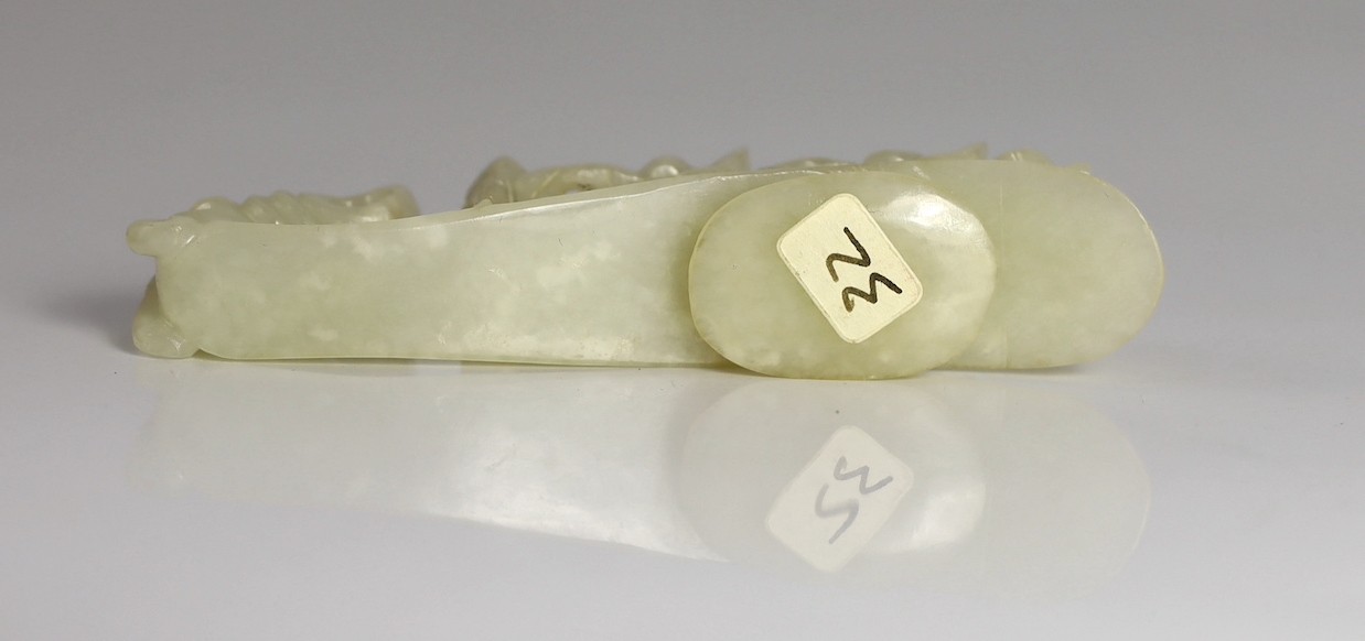 A Chinese white jade ‘dragon’ belt hook, 19th century, 9.4cm long, wood stand